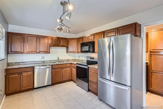 kitchen featuring light stone countertops, sink, and appliances with stainless steel finishes