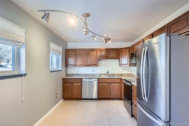 kitchen featuring light stone countertops, sink, and appliances with stainless steel finishes