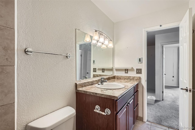 bathroom with tile patterned flooring, vanity, and toilet