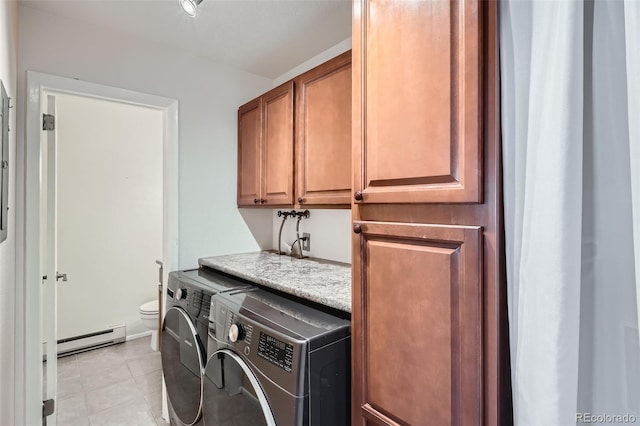 clothes washing area featuring washing machine and clothes dryer, light tile patterned flooring, cabinets, and a baseboard heating unit