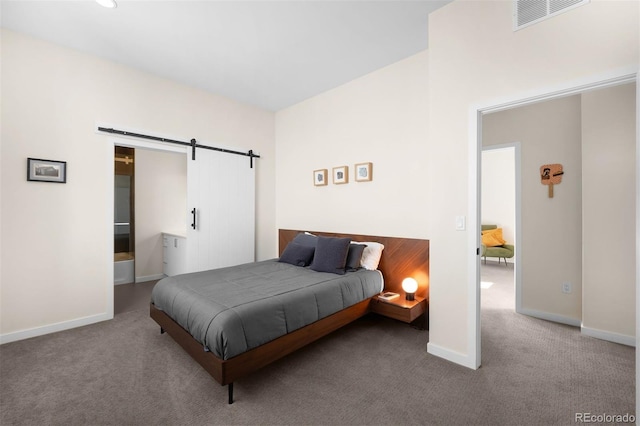 carpeted bedroom with a barn door, visible vents, and baseboards