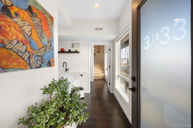 hallway featuring visible vents and a sink