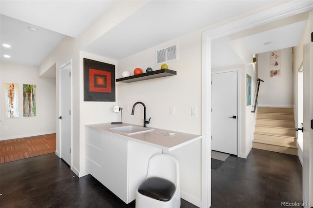 kitchen featuring open shelves, recessed lighting, visible vents, a sink, and baseboards