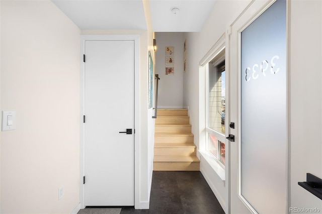 interior space with baseboards and stairway