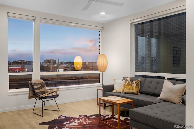 sitting room with a view of city, recessed lighting, ceiling fan, wood finished floors, and baseboards