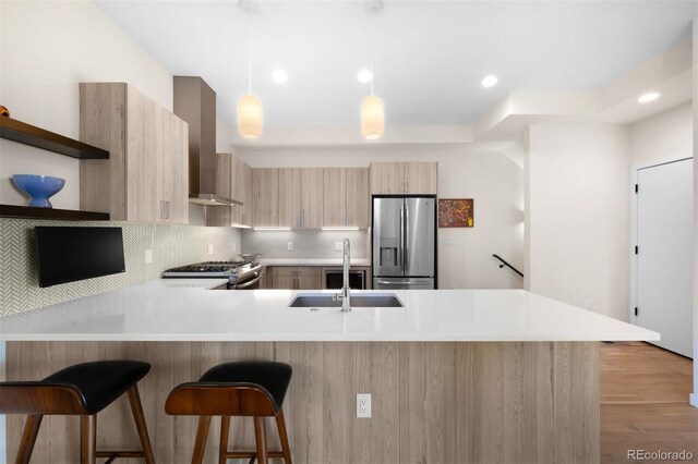 kitchen featuring wall chimney exhaust hood, modern cabinets, stainless steel appliances, open shelves, and a sink