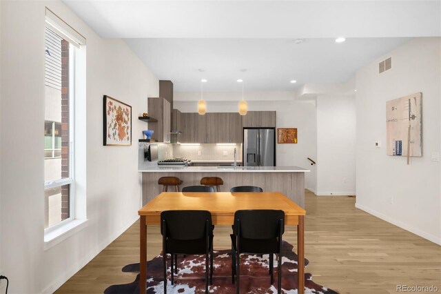 dining area featuring light wood-style floors, recessed lighting, visible vents, and baseboards