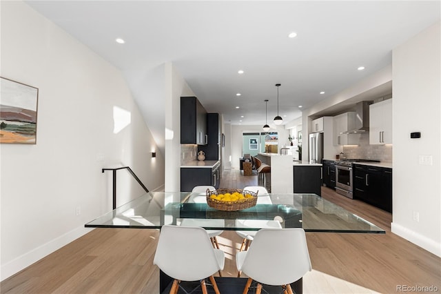 dining area featuring light wood-style flooring, recessed lighting, and baseboards