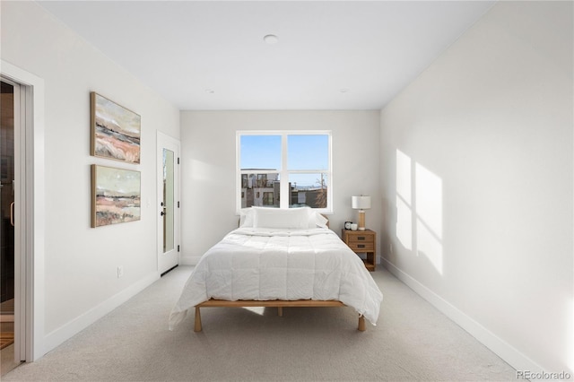 bedroom with light colored carpet and baseboards