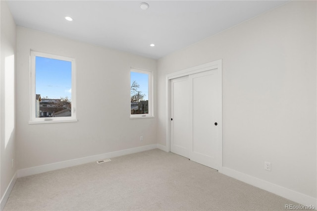 unfurnished bedroom featuring visible vents, baseboards, and carpet