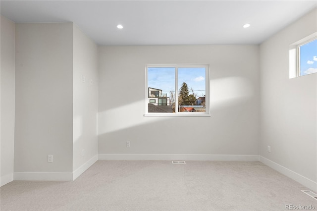 empty room featuring a wealth of natural light, recessed lighting, baseboards, and carpet floors