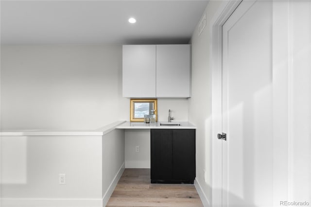 bar with baseboards, visible vents, recessed lighting, a sink, and light wood-type flooring