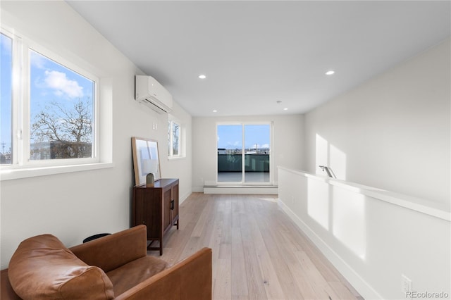 hall featuring a wall mounted air conditioner, baseboards, light wood-style floors, and recessed lighting