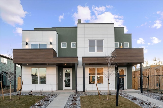 contemporary home featuring fence and stucco siding