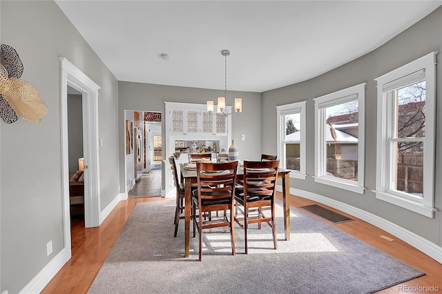 dining room with a notable chandelier and light hardwood / wood-style floors