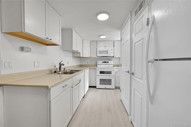 kitchen featuring white cabinetry, sink, white appliances, and light hardwood / wood-style floors