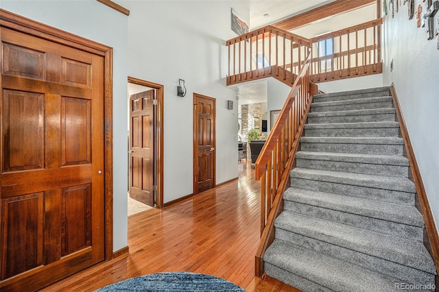 1152 Clubhouse Dr, Broomfield, CO 80020 - staircase with hardwood / wood-style flooring, a towering ceiling, and baseboards