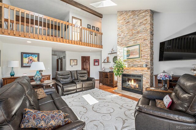 1152 Clubhouse Dr, Broomfield, CO 80020 - living room featuring a high ceiling, a skylight, wood finished floors, and a fireplace