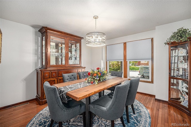 1152 Clubhouse Dr, Broomfield, CO 80020 - dining space with a chandelier, hardwood / wood-style floors, baseboards, and a textured ceiling
