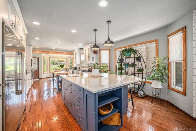 1152 Clubhouse Dr, Broomfield, CO 80020 - kitchen with high quality fridge, white cabinetry, baseboards, open shelves, and recessed lighting