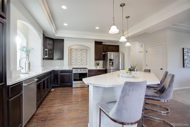 kitchen with dark hardwood / wood-style flooring, stainless steel appliances, a breakfast bar area, and sink