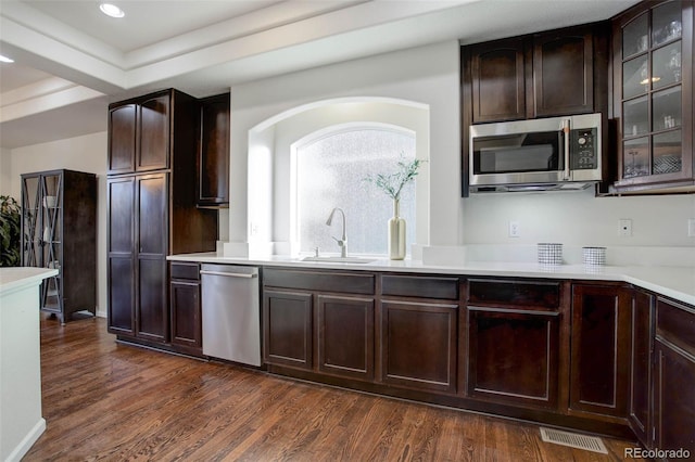 kitchen with dark hardwood / wood-style flooring, sink, stainless steel appliances, and dark brown cabinets