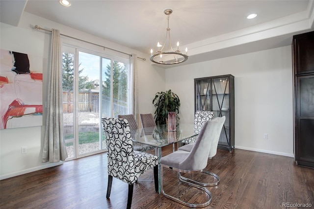 dining space featuring dark wood-type flooring and an inviting chandelier