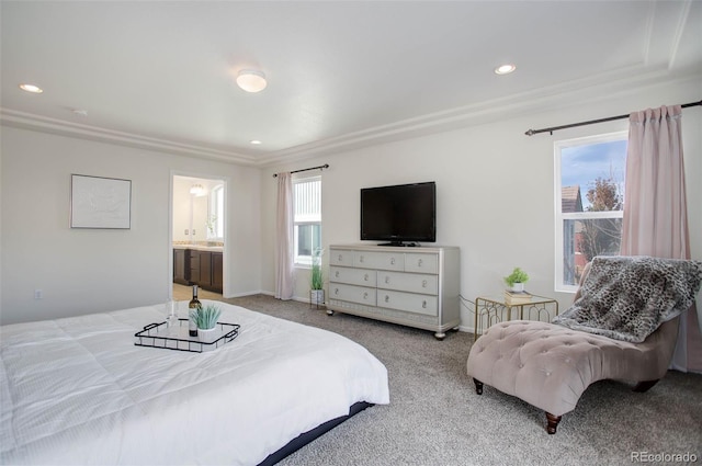 carpeted bedroom with ensuite bath and multiple windows