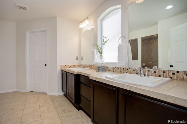 bathroom featuring tasteful backsplash, tile patterned flooring, and vanity