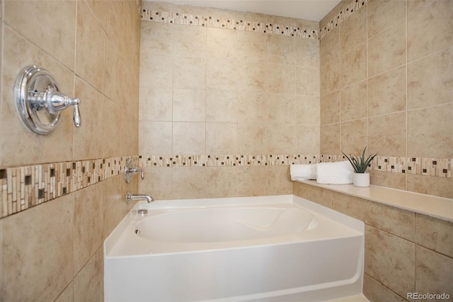 bathroom featuring a bath and tile walls