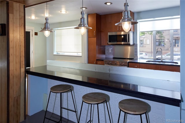 500 E 11th Ave Unit 201, Denver, CO 80203 - kitchen with stainless steel appliances, dark countertops, a breakfast bar, and brown cabinets