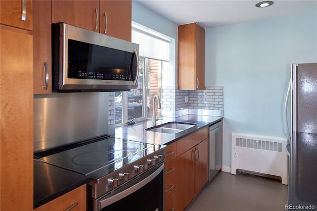 500 E 11th Ave Unit 201, Denver, CO 80203 - kitchen with appliances with stainless steel finishes, radiator heating unit, brown cabinets, tasteful backsplash, and recessed lighting