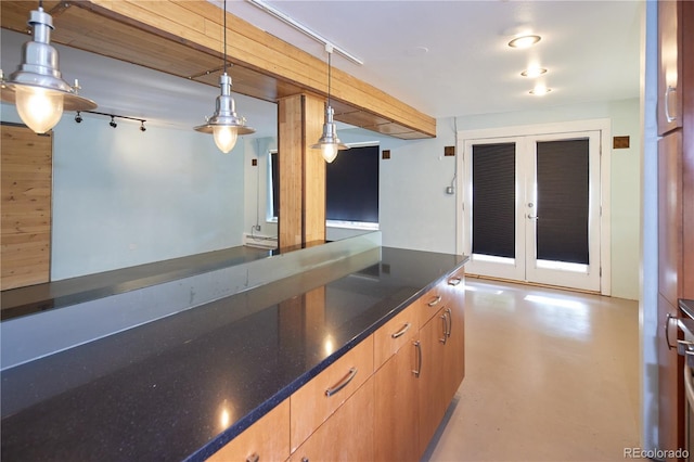500 E 11th Ave Unit 201, Denver, CO 80203 - kitchen with french doors, decorative light fixtures, concrete flooring, and dark stone counters