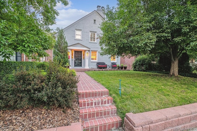428 N Humboldt St, Denver, CO 80218 - view of front of home featuring a front lawn, brick siding, a chimney, and a porch