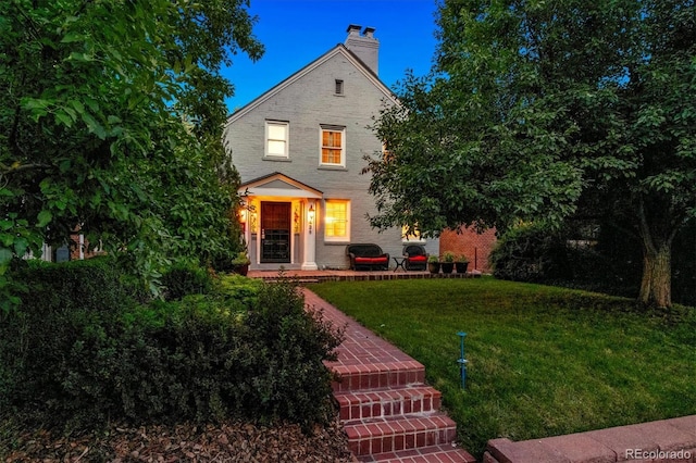 428 N Humboldt St, Denver, CO 80218 - view of front of house featuring a front yard, a chimney, and brick siding