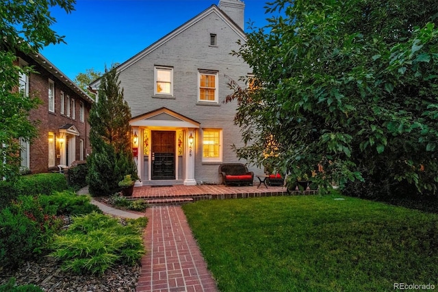 428 N Humboldt St, Denver, CO 80218 - view of front of home featuring a front yard, brick siding, a chimney, and a porch