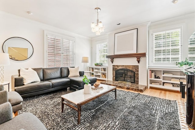 428 N Humboldt St, Denver, CO 80218 - living room with crown molding, light wood-type flooring, a chandelier, and a fireplace