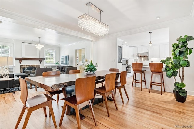 428 N Humboldt St, Denver, CO 80218 - dining room with a chandelier, light wood finished floors, a glass covered fireplace, and ornamental molding