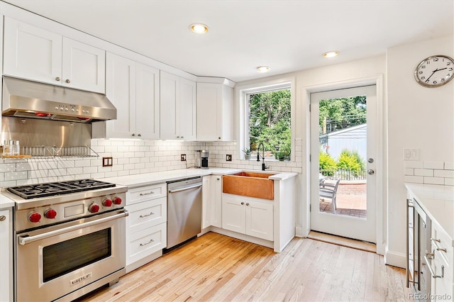 428 N Humboldt St, Denver, CO 80218 - kitchen with stainless steel appliances, under cabinet range hood, light countertops, tasteful backsplash, and recessed lighting