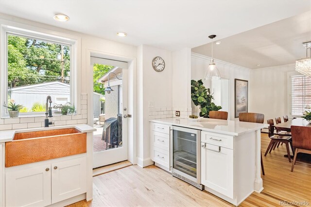 428 N Humboldt St, Denver, CO 80218 - kitchen featuring wine cooler, decorative backsplash, light wood-style floors, and ornamental molding