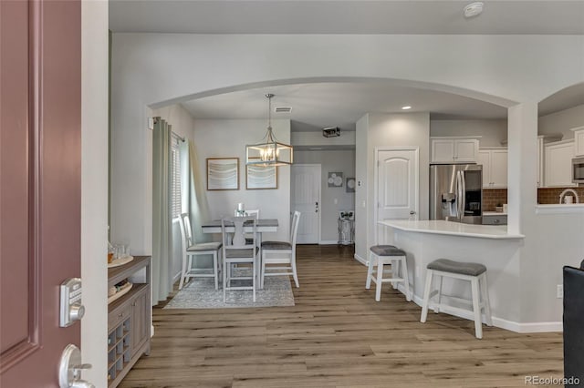 dining space with light hardwood / wood-style floors and a chandelier