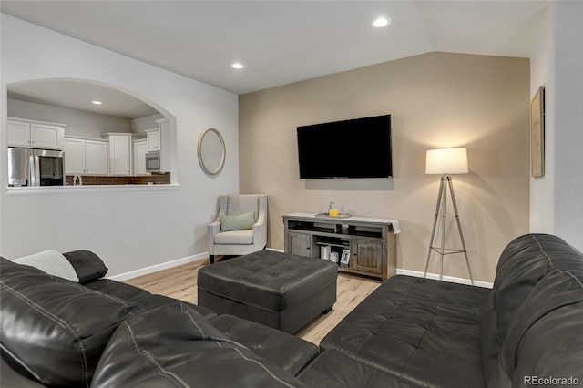 living room featuring light hardwood / wood-style flooring and vaulted ceiling