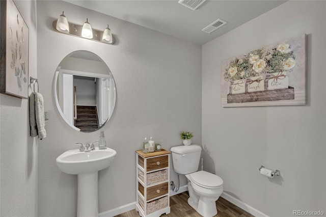 bathroom featuring hardwood / wood-style flooring and toilet