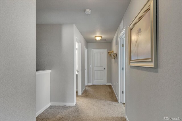 corridor featuring light colored carpet