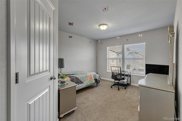 bedroom featuring light colored carpet and a textured ceiling