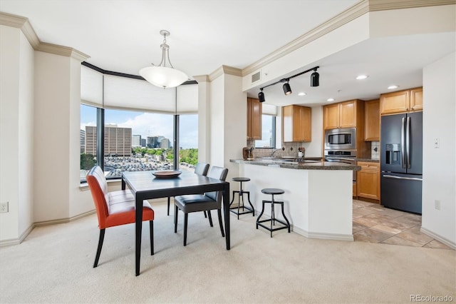 dining space with crown molding and light colored carpet