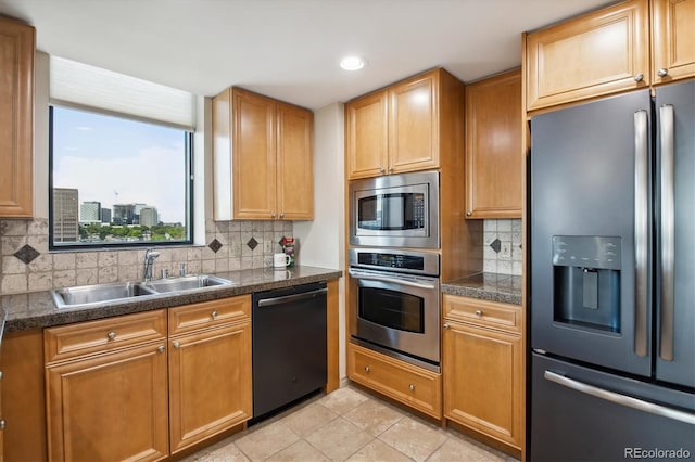 kitchen with appliances with stainless steel finishes, tasteful backsplash, sink, and light tile patterned flooring