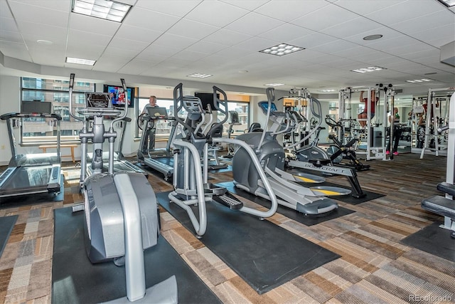 gym with dark carpet and a drop ceiling