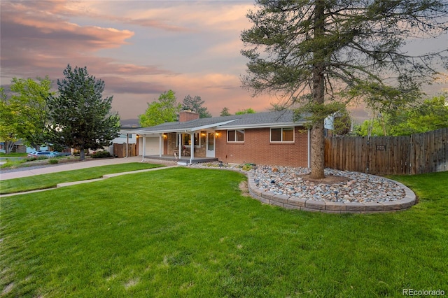 view of front of home with covered porch, driveway, an attached garage, a chimney, and brick siding