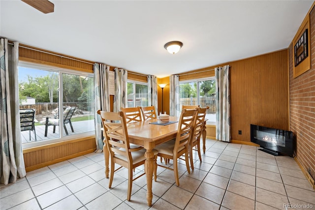 dining area with wood walls and light tile patterned flooring